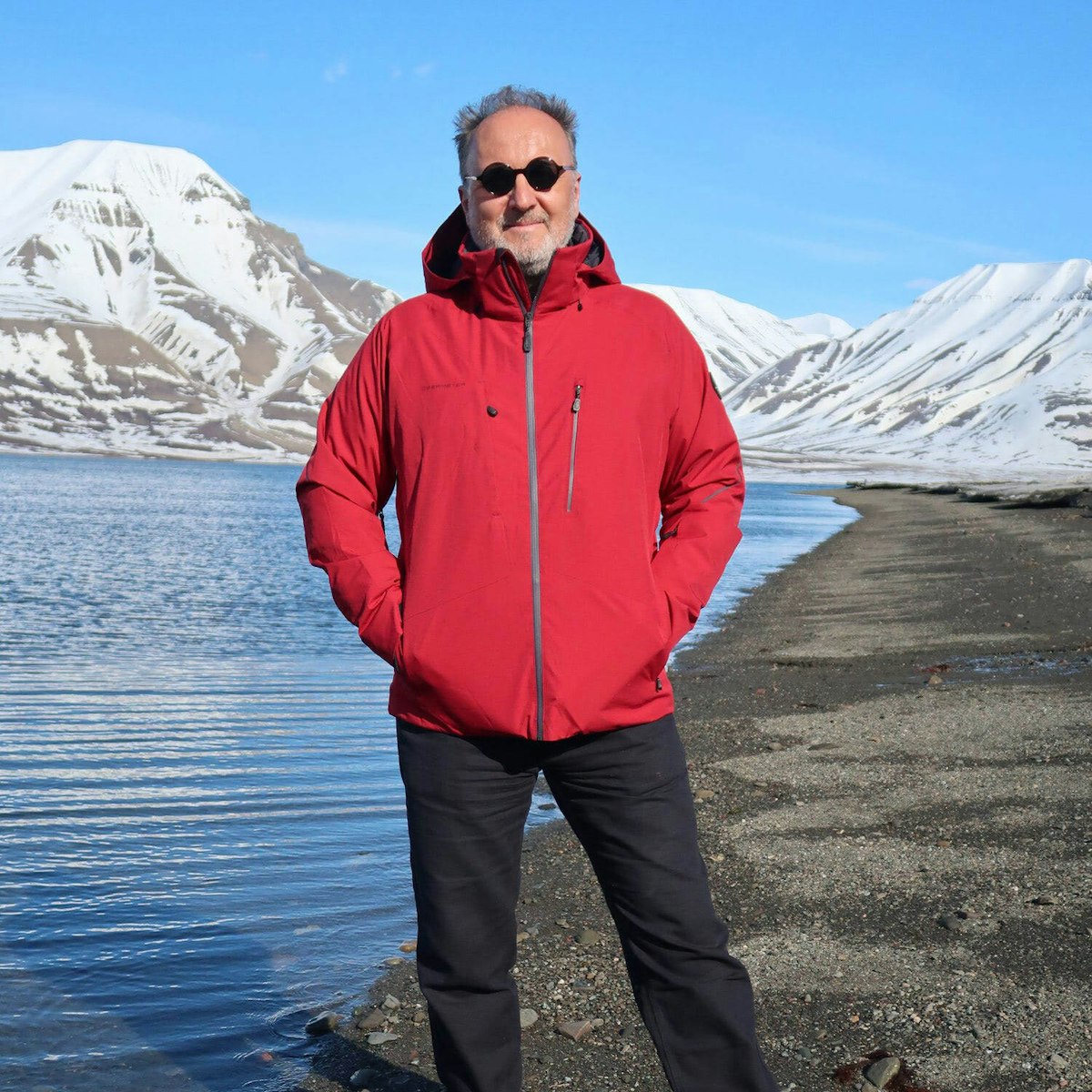 Endi Poskovic in Svalbard, wearing a red parka