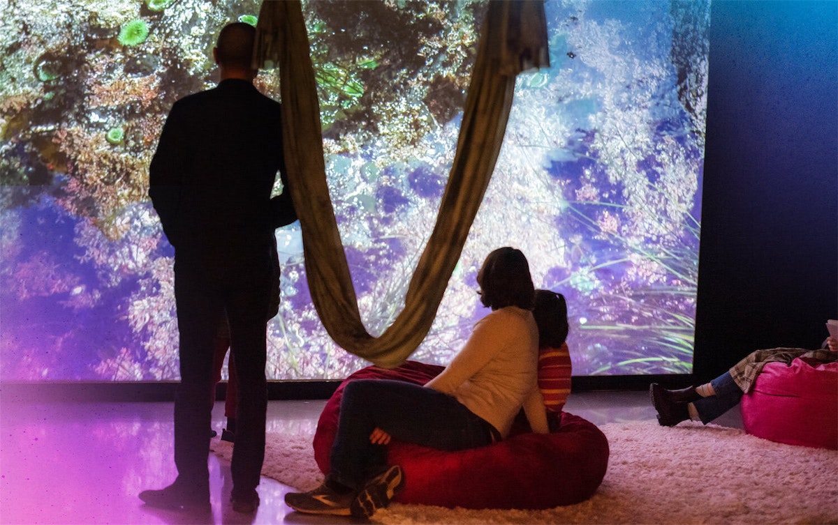 two gallery visitors interact with Ellie Schmidt's installation at the 2022 MFA Thesis Exhibition